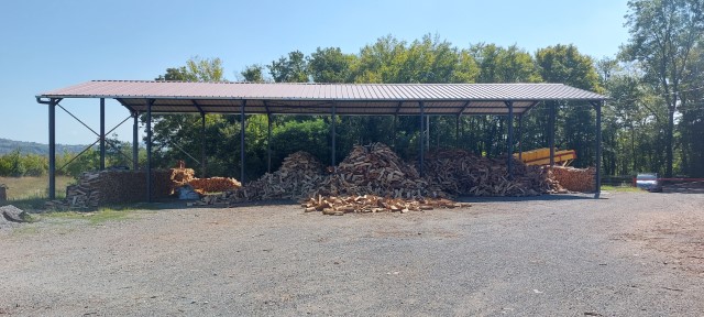 Le bois de chauffage est stocké à l'abri des intempéries sous notre hangar.