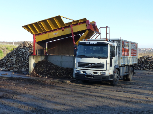 Le camion se place sous le tapis roulant du cribleur, prêt à réceptionner le bois de chauffage