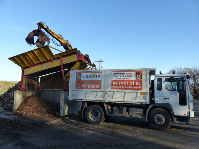 Le bois de chauffage est déposé dans le camion de livraison